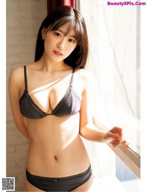 A woman in a gray bikini posing for a picture.