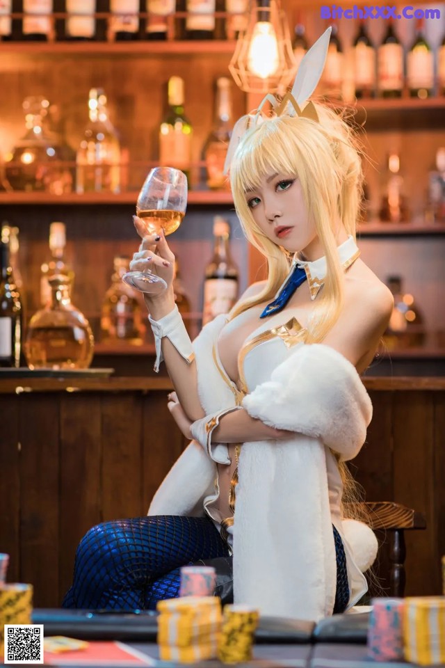 A woman sitting at a bar holding a glass of wine.