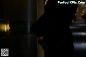 A woman in a business suit is standing on an escalator.