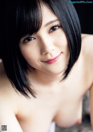 A naked woman laying on top of a bed.