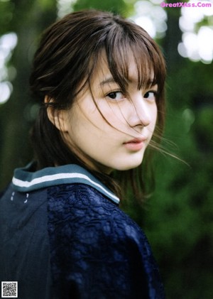 A woman with long brown hair and bangs posing for a picture.