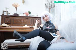 A woman in a black and white lingerie sitting on a white chair.