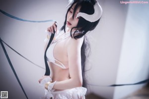 A woman in a white lingerie laying on a bed.
