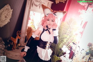 A woman in a maid outfit sitting on a chair.