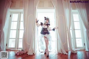 A woman in a maid outfit posing in front of a mirror.