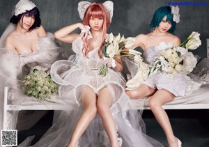 A group of three young women sitting on top of a bed.