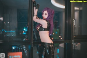 A woman with purple hair is posing on a bed.