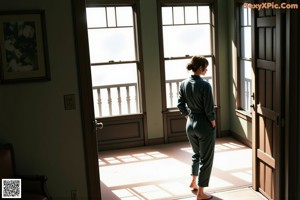 A woman in a green dress sitting on a window sill.