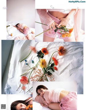 A woman sitting on a bed covered in a blanket.