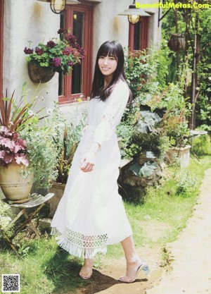 A woman in a white dress sitting on some steps.