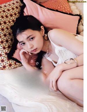 A woman wearing a white sweater and a necklace.