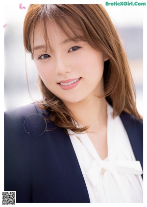 A woman in a business suit is posing for a picture.