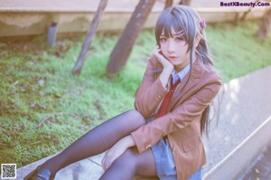 A woman sitting on a bench in a park.