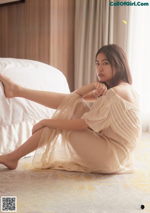 A woman laying on top of a bed in a bedroom.