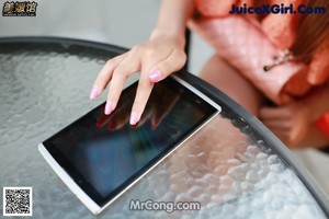 A woman sitting on a bench holding a tablet computer.