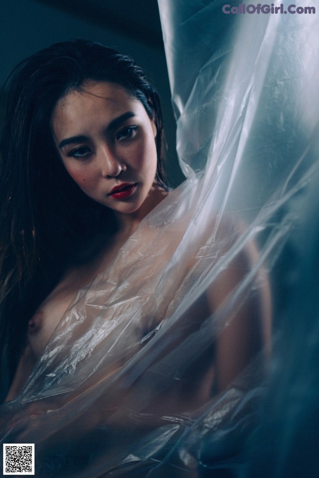 A naked woman wrapped in plastic is posing for the camera.