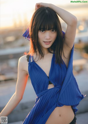 A woman with long black hair and bangs is posing for a magazine.