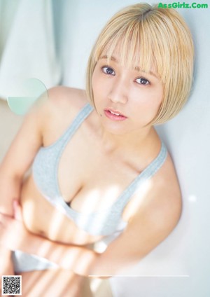 A woman in a white bikini posing for a magazine.