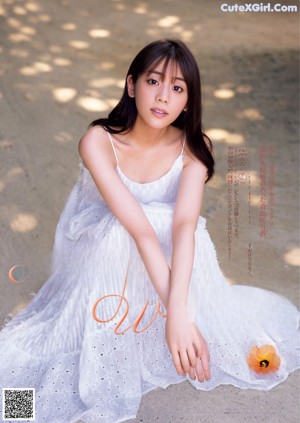 A woman in a floral dress posing for a magazine.