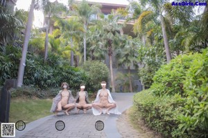 A group of naked women sitting on the steps of a building.