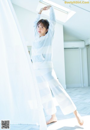 A woman laying on a bed with her hands behind her head.