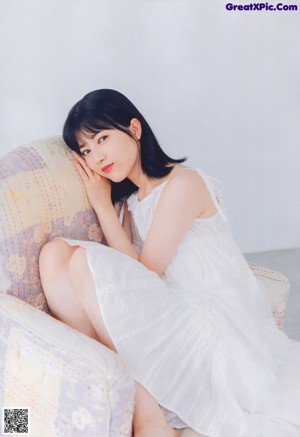 A young woman leaning on a window sill.