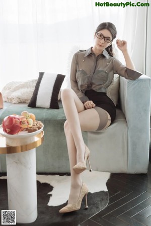 A woman in lingerie and stockings posing in front of a television.