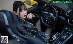 A woman sitting in the driver's seat of a yellow car.