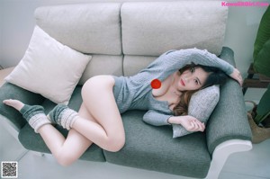 A woman laying on a couch with her feet up on the couch.