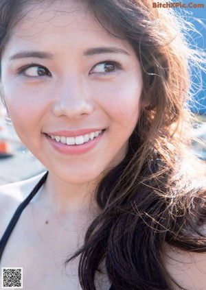 A woman in a black bathing suit standing on a balcony.